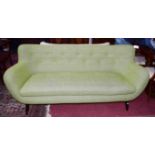A MODERN DESIGNER STYLE THREE SEATER SETTEE, covered in green fabric, with fixed cushion,