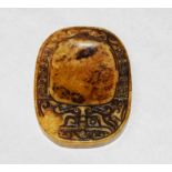 A CHINESE CARVED INK STONE, with incised cyphers and Greek key border, 3" (7.5cm)h x 2.25" (5.5cm).