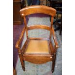 AN OLD BEECH FRAMED ARM CHAIR COMMODE.
