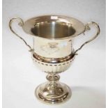 A TWO HANDLED SILVER PLATED CHAMPAGNE COOLER, with half reeded body, on stem base, 13" (33cm)h.