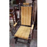 AN EDWARDIAN ROCKING CHAIR, covered in old brocade.