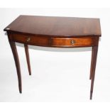 A REGENCY STYLE BOW FRONTED MAHOGANY SIDE TABLE, with cross banded top and two frieze drawers,