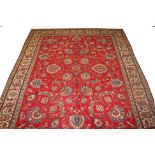 A FINE RED GROUND TABRIZ CARPET, with all over floral pattern, inside a wide ivory border,