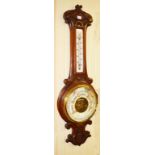 A CARVED OAK ANEROID WHEEL BAROMETER, 33" (84cm).