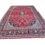 A PERSIAN HERIZ CARPET, with centre ivory and navy blue medallion, with all over floral design,