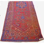 A PERSIAN SAROUK RUNNER, the red field with a circular crucifom dark blue medallion,