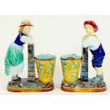 A PAIR OF VICTORIAN MAJOLICA BOY AND GIRL WITH BASKET SPILL VASES, CIRCA 1880