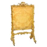 AN ORNATE VICTORIAN GILTWOOD AND COMPOSITION FIRESCREEN WITH (FRAYED) FABRIC BANNER (LOSSES)