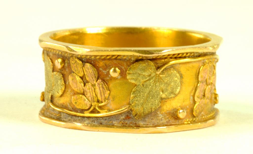 A GOLD BAND RING DECORATED IN GREEN AND RED GOLD WITH GRAPEVINES, MARKED W&B18, CIRCA 1900, SIZE