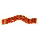 A GOLD AND CORAL THREE STRAND BRACELET WITH GOLD AND CARVED CORNELIAN CYLINDER CLASP