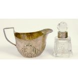 A VICTORIAN SILVER CREAM JUG, 11CM L, LONDON 1880 AND A SILVER MOUNTED CUT GLASS SCENT BOTTLE AND