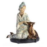 A MARCELL GOLDSCHEIDER EARTHENWARE FIGURE OF A SEATED EASTERN LADY STROKING A DEER, C1949 23cm h,