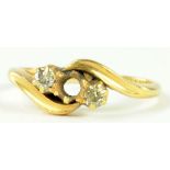 A DIAMOND THREE STONE CROSSOVER RING IN 18CT GOLD (ONE DIAMOND DEFICIENT), 2.9G GROSS