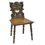 AN ITALIAN CARVED WALNUT HALL CHAIR WITH GROTESQUE MASK BACK, 84CM H, 19TH CENTURY