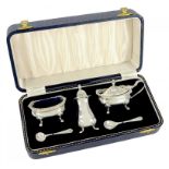 AN ELIZABETH II SILVER THREE PIECE CONDIMENT SET WITH BLUE GLASS LINERS AND PAIR OF SILVER SPOONS,