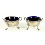 A PAIR OF GEORGE V SILVER TWO HANDLED AND GADROONED SALT CELLARS ON THREE FEET, 7CM W, BIRMINGHAM