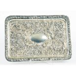 AN EDWARD VII SILVER DRESSING TABLE TRAY, RICHLY EMBOSSED WITH FLOWERS AND SCROLLING FOLIAGE, 29CM