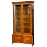 AN OAK DISPLAY CABINET OR BOOKCASE ENCLOSED BY A PAIR OF GLAZED DOORS, THE LOWER PART WITH