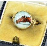 A GOLD RING WITH ASSOCIATED ENAMEL ROUNDEL OF THE HEAD OF A HORSE, MARKED 9K, 2.7G GROSS