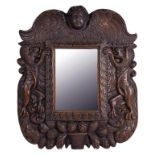 A FRENCH CARVED AND STAINED SOFTWOOD MIRROR, CRESTED BY A CHERUB'S HEAD AND FLANKED BY LIONS, 40CM X