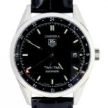 A TAG HEUER STAINLESS STEEL SELF WINDING CARRERA TWIN-TIME WRISTWATCH, THE BLACK DIAL WITH DATE,