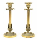 A PAIR OF VICTORIAN BRASS CANDLESTICKS ON FLUTED, LEAD WEIGHTED FOOT