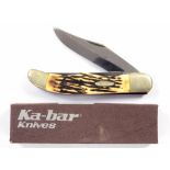 A KA-BAR FOLDING KNIFE WITH ANTLER SCALES AND NICKEL PLATED MOUNTS, UNUSED, BOXED