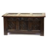 A CARVED OAK BLANKET CHEST WITH PANELLED LID, 108CM W