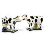 A PAIR OF ENGLISH EARTHENWARE COW CREAMERS WITH MILKMAIDS on black and green base, 14cm h ++Small