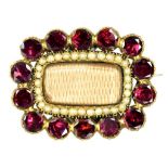 AN EARLY VICTORIAN SPLIT PEARL, FOILED GARNET AND GOLD MOURNING BROOCH