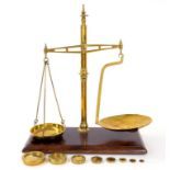 A VICTORIAN BRASS BEAM SCALE, WITH BRASS PANS AND TURNED COLUMN, ON MAHOGANY BASE, 60CM H, WITH A