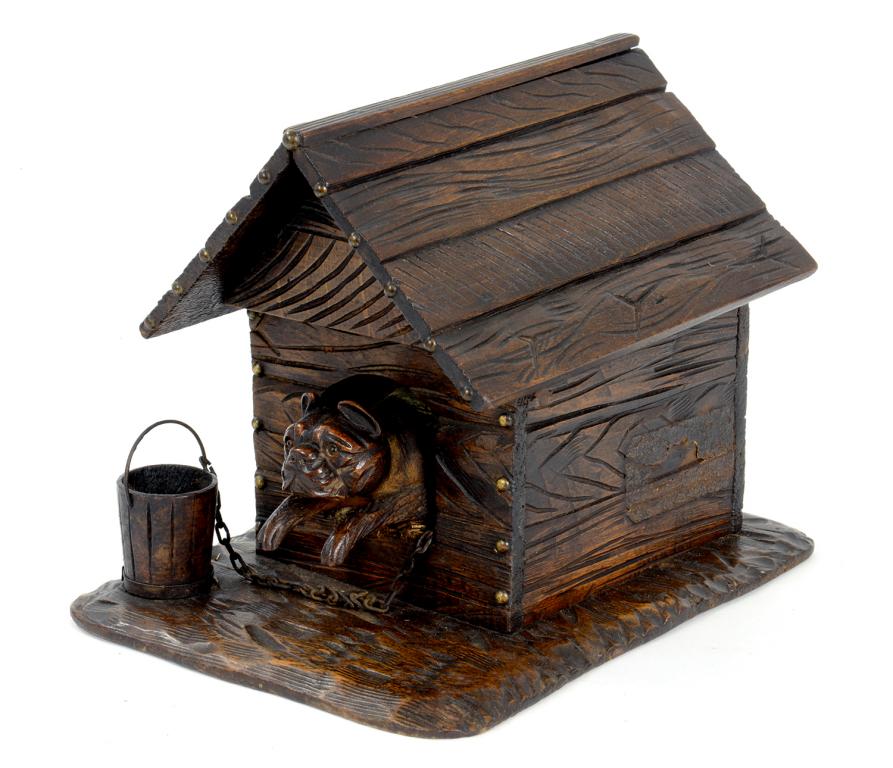 A SWISS CARVED AND DARK STAINED LIMEWOOD CIGAR BOX IN THE FORM OF A DOG IN A KENNEL, 24.5CM W,