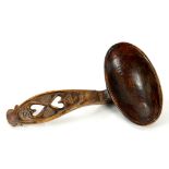 TREEN. A CARVED AND VARNISHED WOOD LOVE SPOON WITH OVAL BOWL, THE HANDLE PIERCED WITH TWO HEARTS,