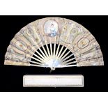 A PALAIS ROYAL FAN, THE SILK LEAF DECORATED WITH SEQUINS AND PAINTED WITH A YOUNG WOMAN AND TROPHIES
