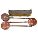 A VICTORIAN PIERCED BRASS FENDER 80CM W AND THREE VICTORIAN COPPER WARMING PANS WITH TURNED