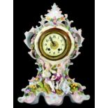 A CONTINENTAL PORCELAIN FLORAL ENCRUSTED CLOCK THE BASE SET WITH A PIPING SHEPHERD AND COMPANION AND