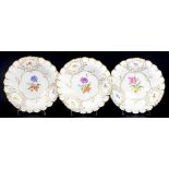 THREE MEISSEN MOULDED GILT DISHES PAINTED WITH FLOWERS, 29.5CM DIAM, CANCELLED CROSSED SWORDS MARK