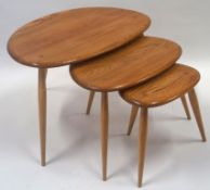 A nest of three Ercol tables, each with three turned tapering legs, manufacturers label, 39cm high,