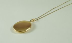 A plain oval locket pendant, stamped '585' to the bale; on chain, stamped '14K', 17.
