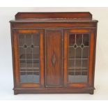 A mid 20th century oak display cabinet with two stained glass and lead doors on plinth base with