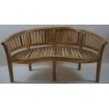A 20th century wooden garden bench of curved form on square legs,