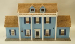 A 20th century doll's house, the front painted blue with four white columns,