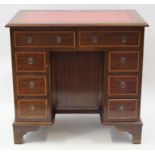 An Edwardian mahogany pedestal desk with leather inset top above an arrangement of eight drawers on