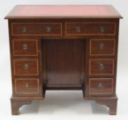 An Edwardian mahogany pedestal desk with leather inset top above an arrangement of eight drawers on
