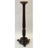 A mahogany torchere with octagonal support with round base on three carved flat feet,