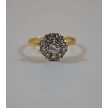 An eleven stone diamond cluster ring, stamped '18ct', the central brilliant cut of approximately 0.