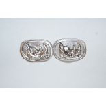 A pair of silver coloured cufflinks, with a design of a rhinoceros,