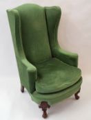 An early 20th century Colonial wing back arm chair with carved cabriole legs