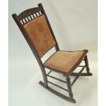 A stained beech rocking chair with upholstered back and seat