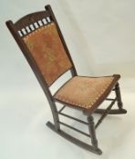 A stained beech rocking chair with upholstered back and seat